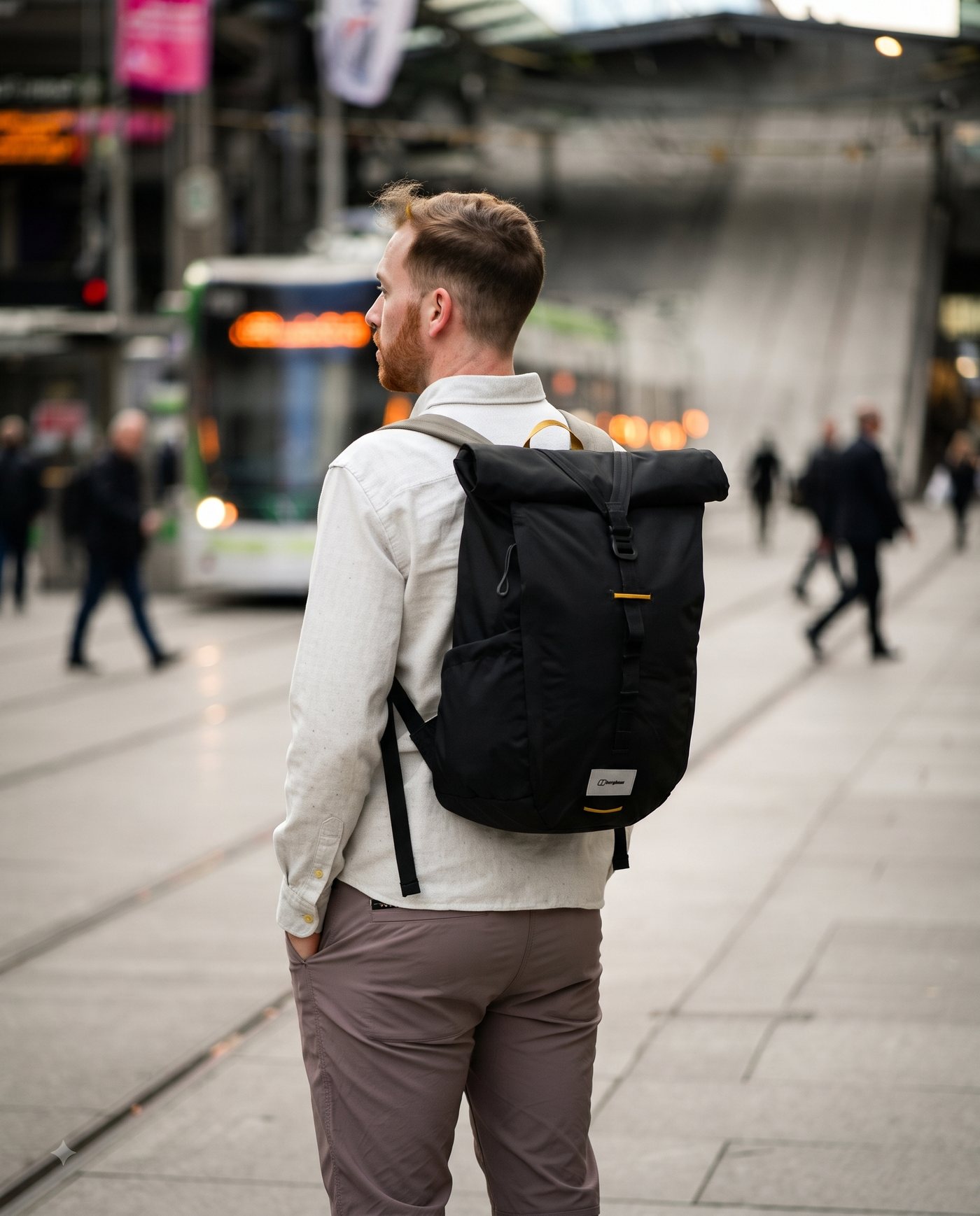 Commuter with a black roll-top pack on a city street